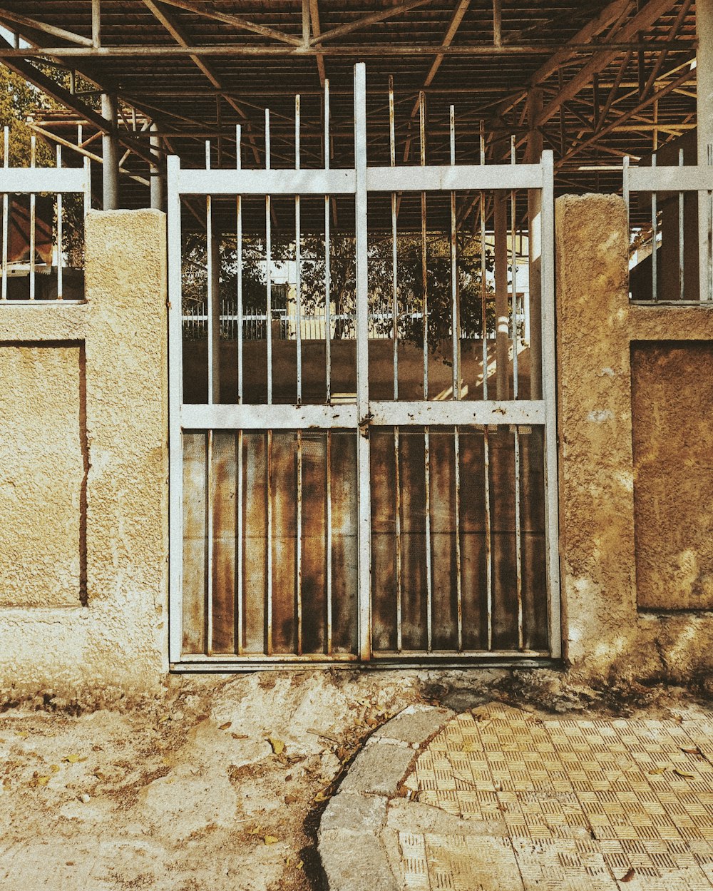 Portón de fierro de dos hojas entre muros